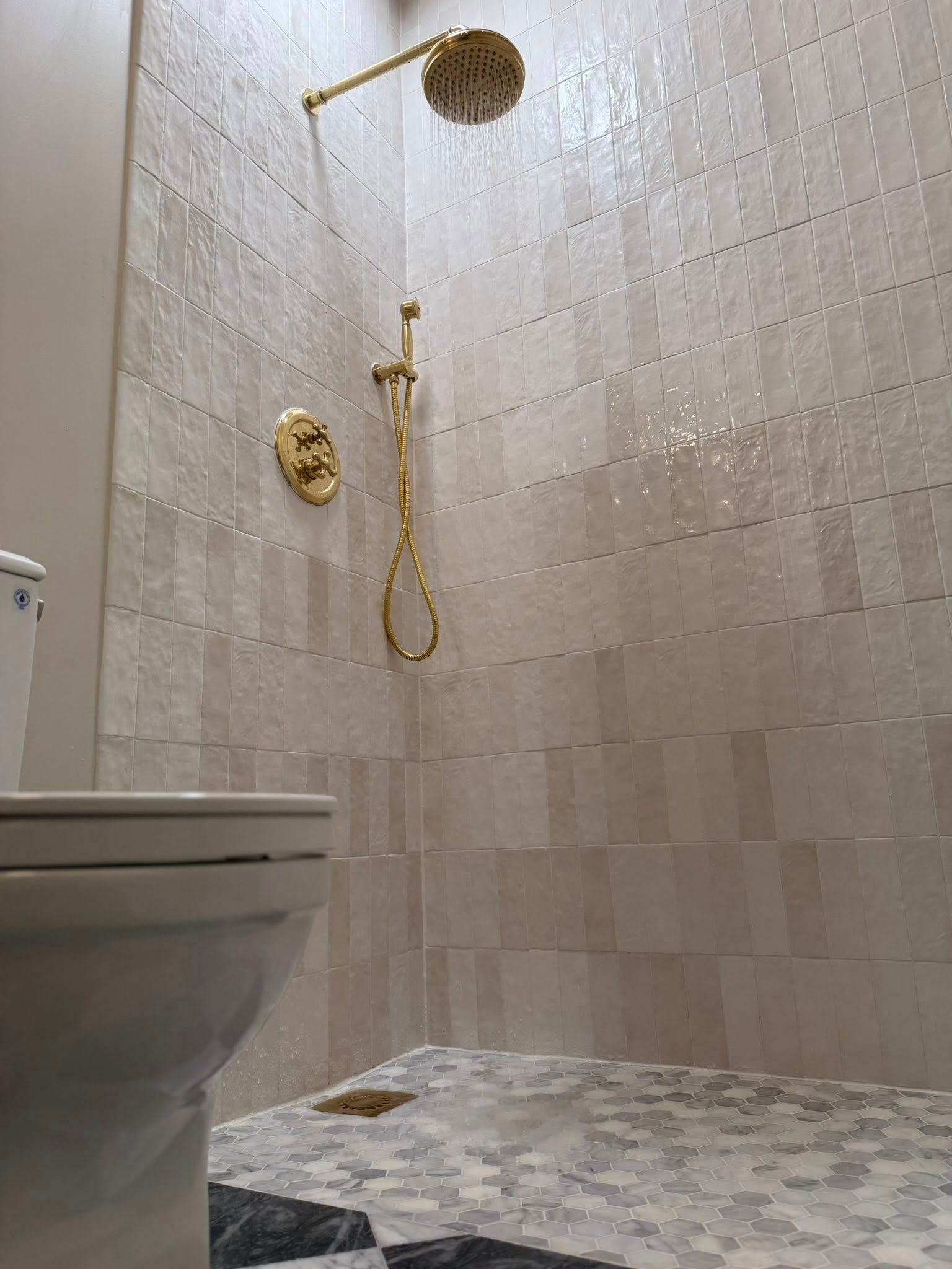 Tile shower with gold fixtures